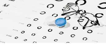 Kontaktlinsen und Brille liegen auf einem Optiker Sehtest